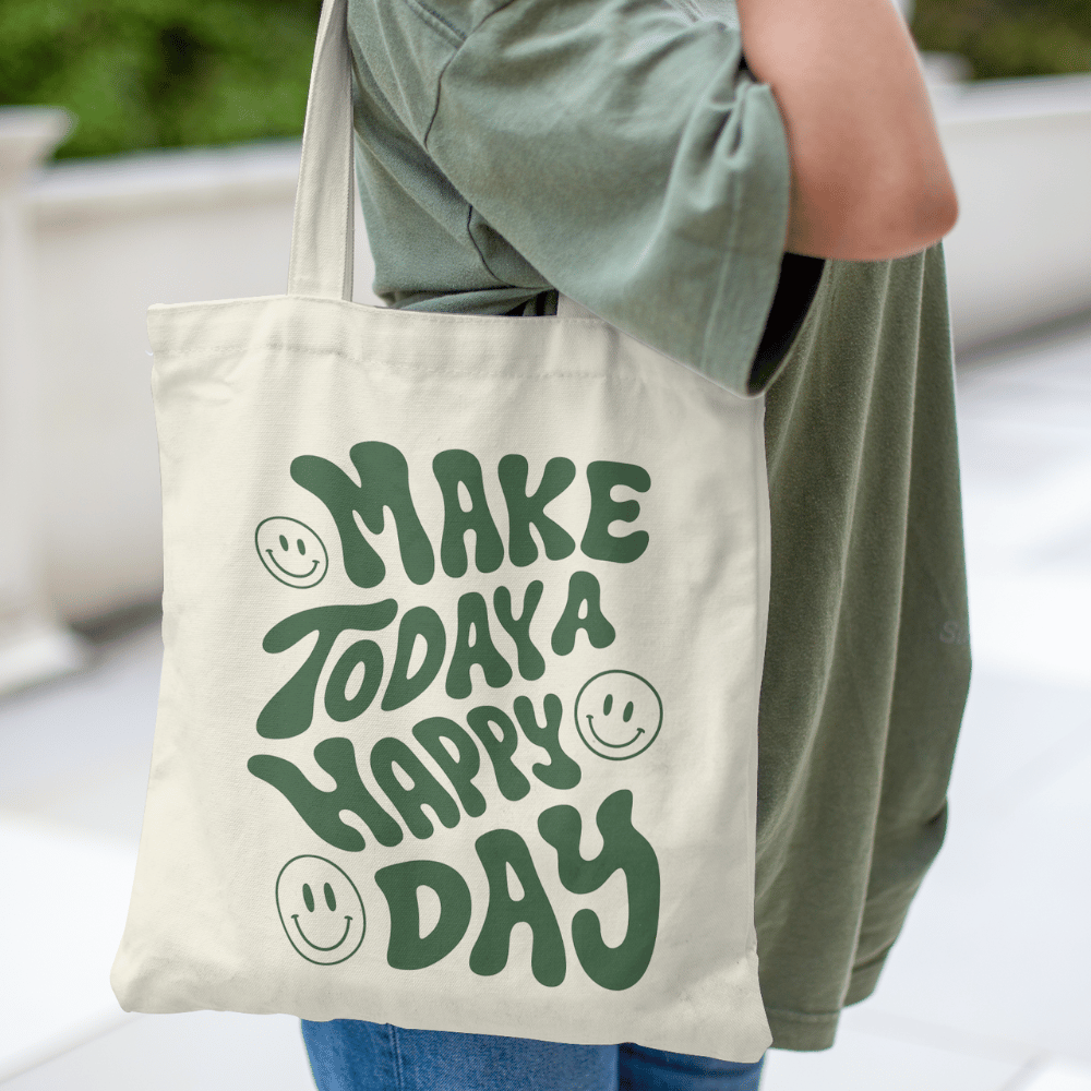 Organic cotton tote bag with “Make Today a Happy Day” design, reusable and eco-friendly with long handles.