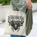 Tote bag with black gothic-style three-headed Doberman illustration and "Power Unleashed" text – edgy canvas bag for dog lovers and alt fashion fans