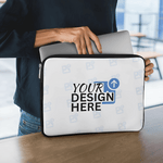 Person placing a laptop into a customisable white laptop sleeve with “Your Design Here” placeholder text in a modern workspace.