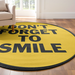 Round yellow rug with motivational quote ‘Don’t Forget to Smile’ in bold black letters, placed on a light wooden floor.