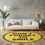Round yellow rug with motivational quote ‘Don’t Forget to Smile’ in bold black letters, placed on a light wooden floor.