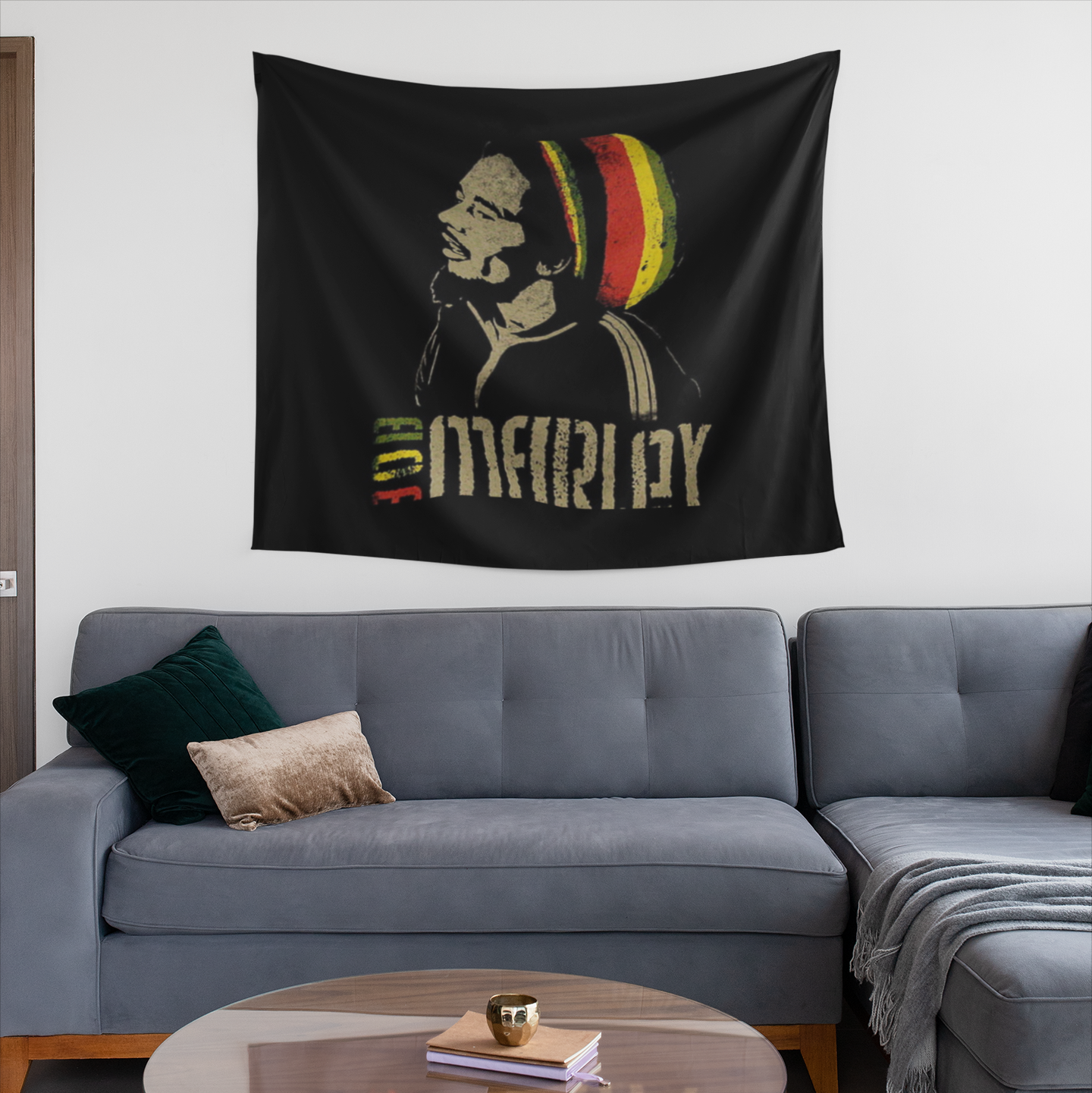 Black tapestry featuring a stencil-style portrait of Bob Marley in profile wearing a red, yellow, and green Rasta beanie, with the text "Bob Marley" below in distressed beige lettering, and "Bob" colored in green, yellow, and red.