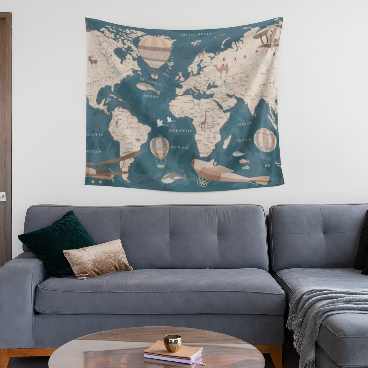 Tapestry depicting a stylized world map with beige continents over a teal ocean background, decorated with illustrated hot air balloons, planes, animals, and ships in a soft vintage color palette.